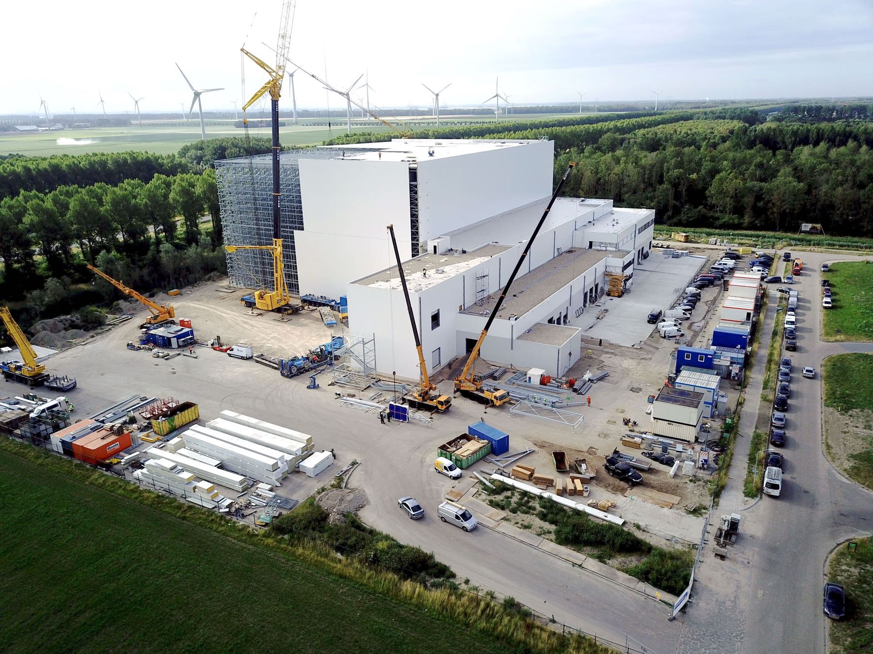 Aerial view of a cold store under construction, cranes working around the high-bay structure